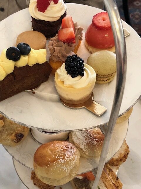 Afternoon Tea tray of sweets, scones, and sandwiches. Illustration for England Travels post